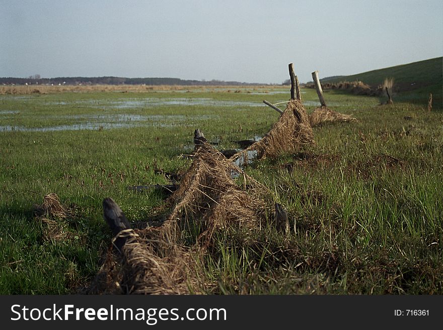 Broken fence on wet meadow near the Vistula river
