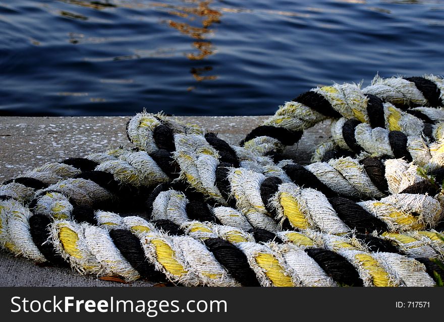 Marine rope lying on pier overlooking water.