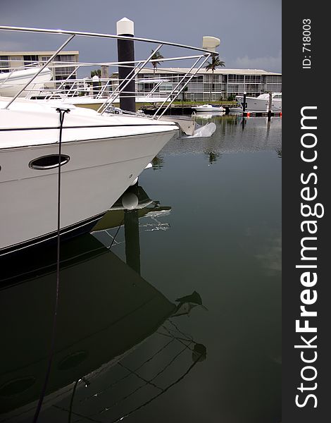 Image of the front of a fishing yacht at a marina with condos in the background. Image of the front of a fishing yacht at a marina with condos in the background