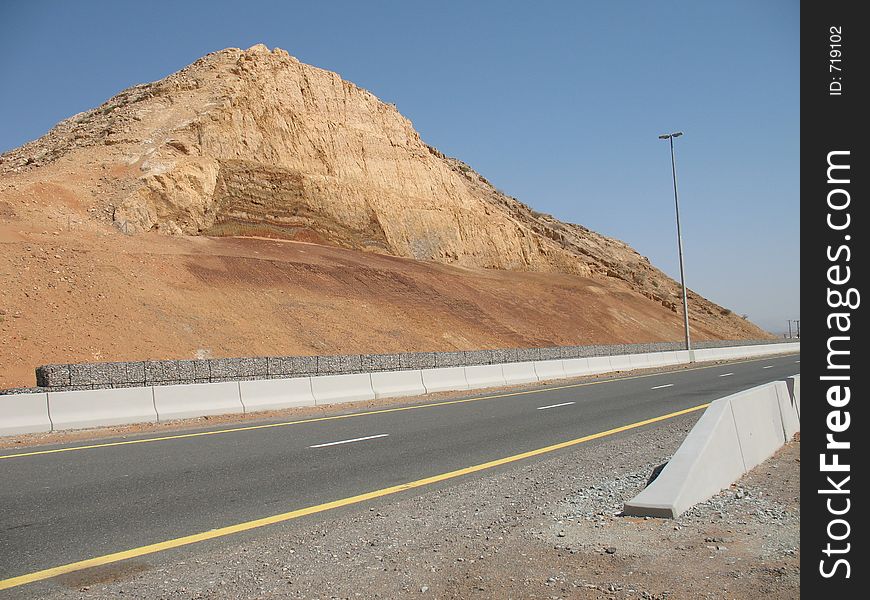 A two lane highway from Sharjah to Kalba with a hillock in the background. A two lane highway from Sharjah to Kalba with a hillock in the background.