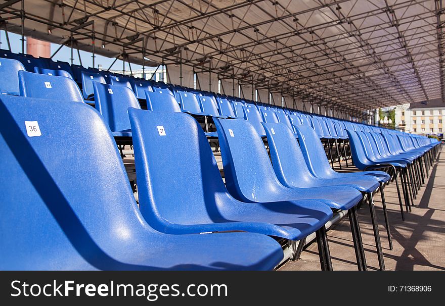Plastic blue seats in a stadium outside closeup