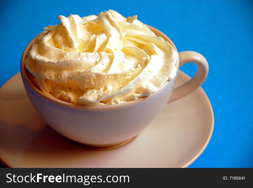 Foamy latte with whipped cream in white cup
