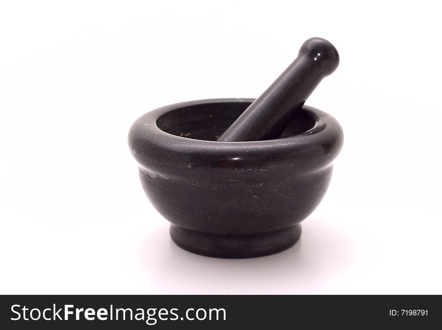 Stone mortar with a pestle for crushing of spices. It is isolated on a white background