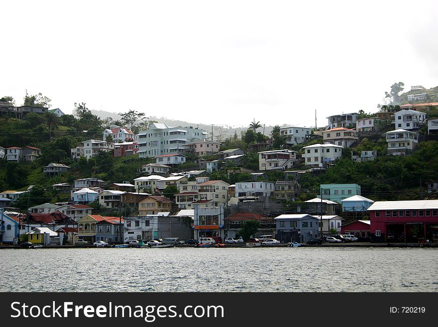 Just pulling into port of one of the islands in the Caribbean, showing houses and industries on the hillside. Just pulling into port of one of the islands in the Caribbean, showing houses and industries on the hillside