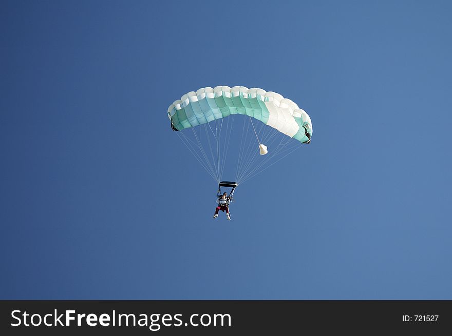 Skydivers perpare to land during a tandem jump. Skydivers perpare to land during a tandem jump.