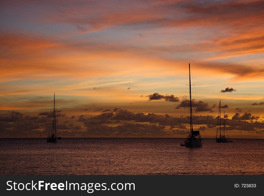 Colourful caribbean sunset with sailboats. Colourful caribbean sunset with sailboats