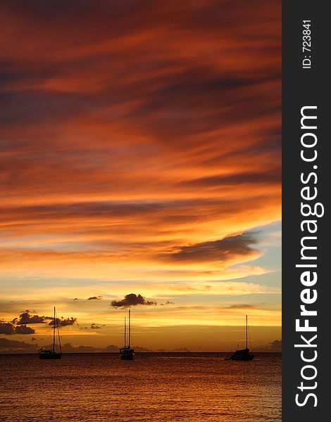 Colourful caribbean sunset with sailboats. Colourful caribbean sunset with sailboats