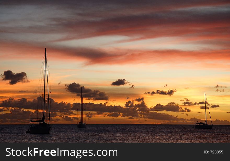 Colourful caribbean sunset with sailboats. Colourful caribbean sunset with sailboats