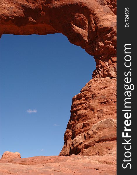 Cropped close up of a natural stone arch with blue sky showing through. Arches National Park, Utah, USA.