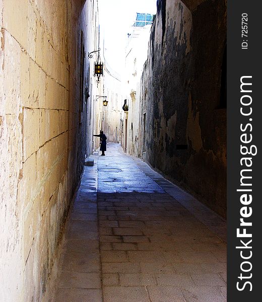 The ancient city of Mdina, Malta. In these silent street a resident returns to home. The ancient city of Mdina, Malta. In these silent street a resident returns to home.