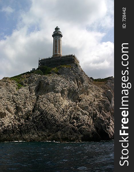 Small lighthouse sitting atop large cliff. Small lighthouse sitting atop large cliff