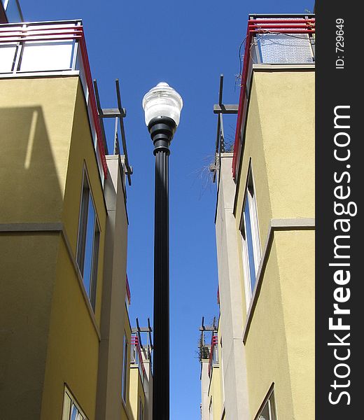 A lamp post between two symmetrical buildings.