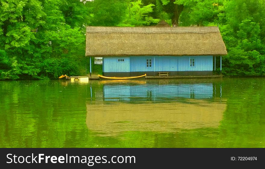 spooky interpretation with overfiltered view with blue wooden house on the green lake in autumn season. spooky interpretation with overfiltered view with blue wooden house on the green lake in autumn season