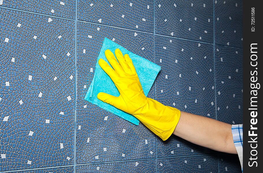 Woman washes a tile in the bathroom, hand closeup