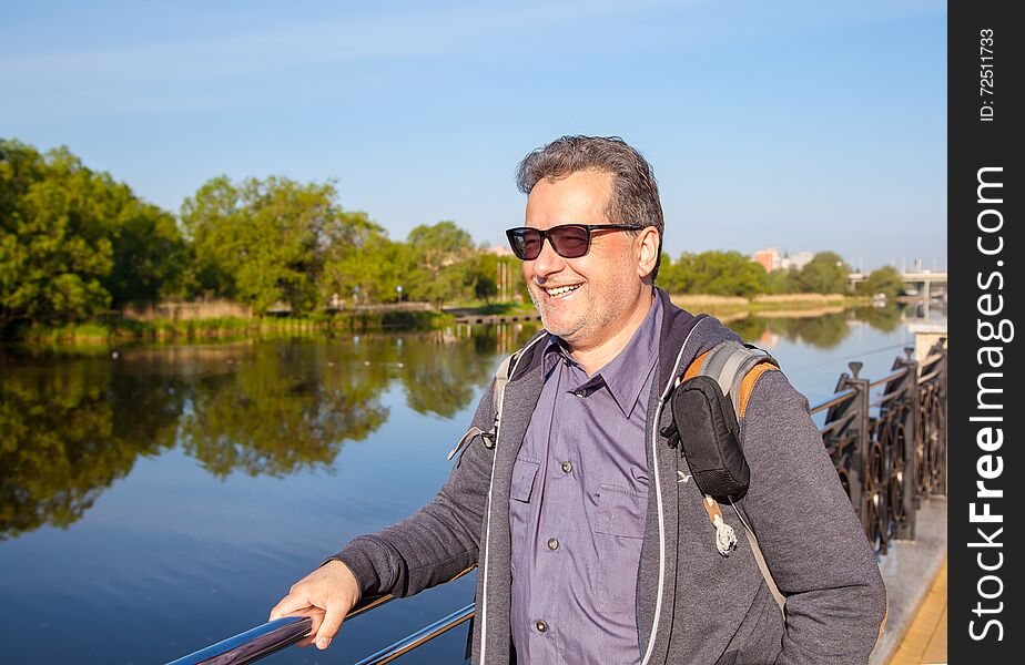 Elderly Man With Glasses Walking Along The Promenade