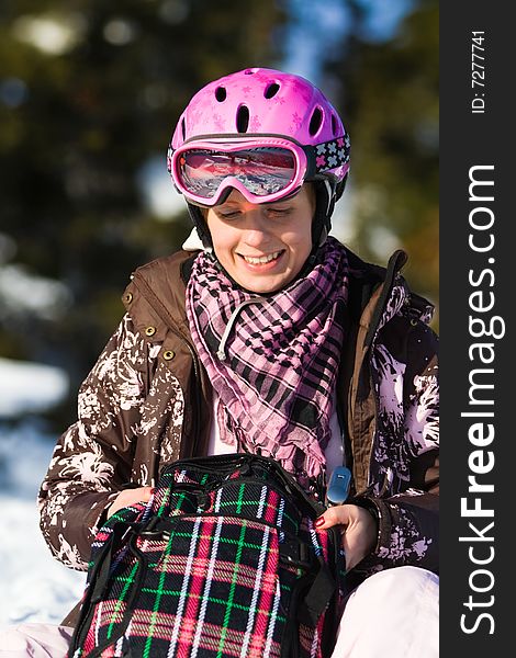 Girl with backpack sitting on snow