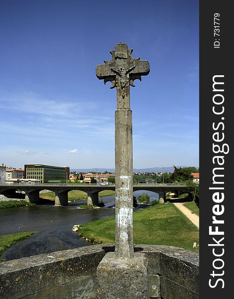 Stone cross on bridge in town of carcassonne, france