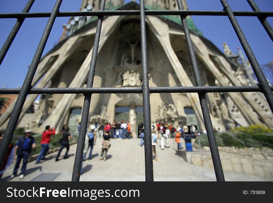 Gaudi's famous sagrada familia church in barcelona seen through iron gate