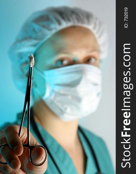 Female doctor/surgeon in scrubs with hemostat. Female doctor/surgeon in scrubs with hemostat