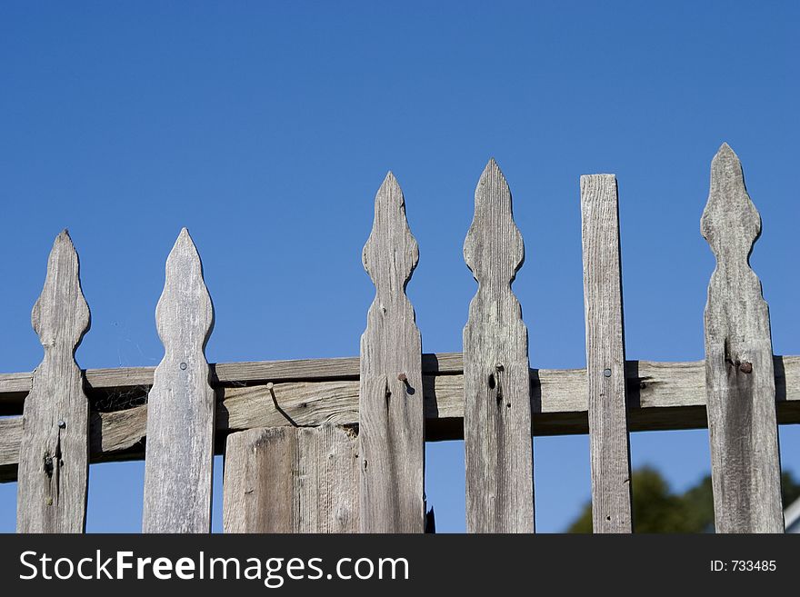 A rustic picket, fence in a small town. A rustic picket, fence in a small town.