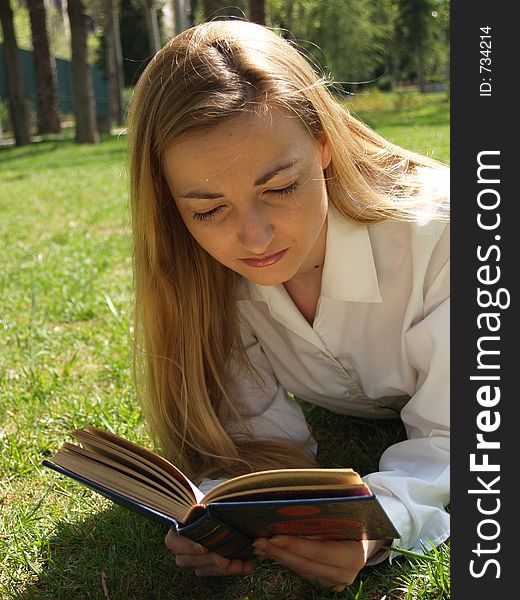 Woman Reading On The Grass