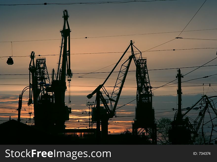 Silhouette of cranes in the sea-port. Silhouette of cranes in the sea-port