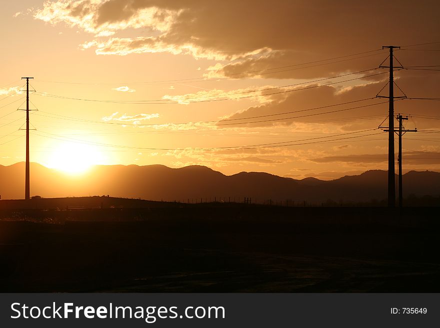 Powelines with sun setting behind mountains. Powelines with sun setting behind mountains