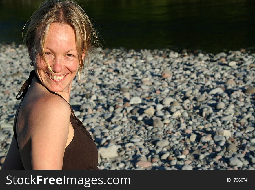 A girl smiles against a smooth rock background. A girl smiles against a smooth rock background.