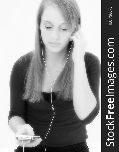 Black and white teen girl listening to digital music player.