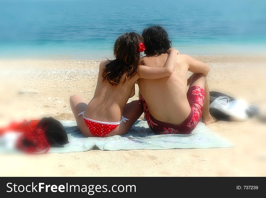 A cute couple cuddles on an italian beach