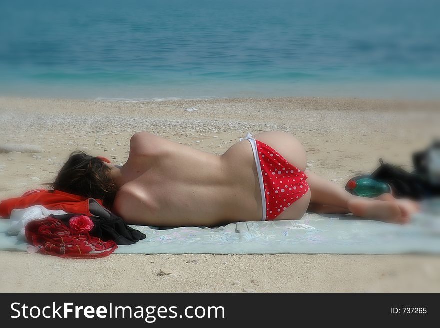 Topless babe takes a nap on the beach