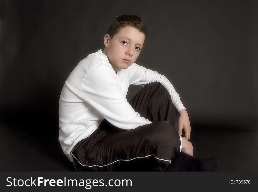 Teenager dressed in black and white against black backdrop. Teenager dressed in black and white against black backdrop