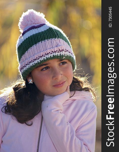 Little girl posing in ski hat and sweater on a fall or winter day. Little girl posing in ski hat and sweater on a fall or winter day