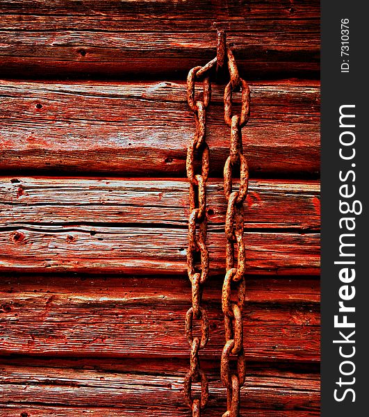 Rusted chain on red painted wooden cottage in northern sweden in skuleskogen national park