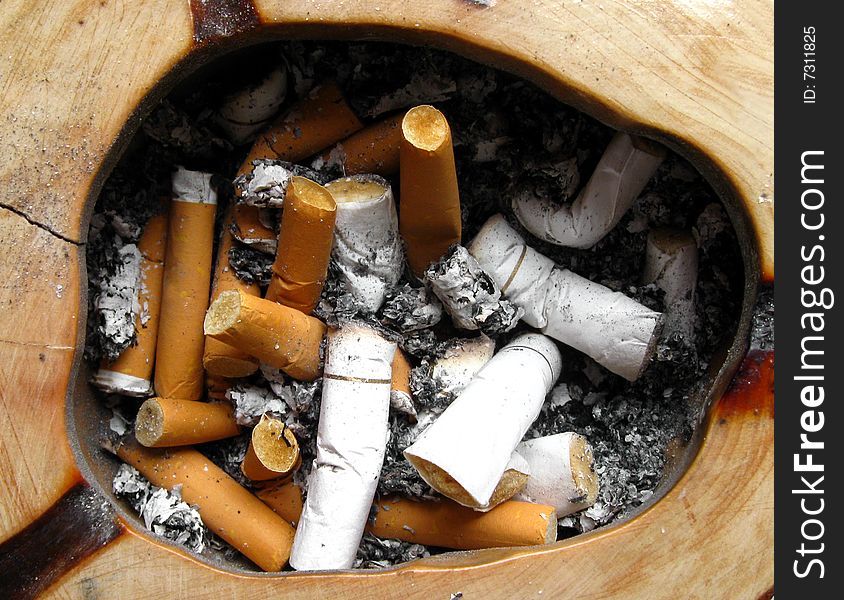 Wooden ashtray with cigarette butts