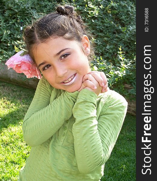 This is a picture of a little girl posing for a picture with a flower in her hair. This is a picture of a little girl posing for a picture with a flower in her hair