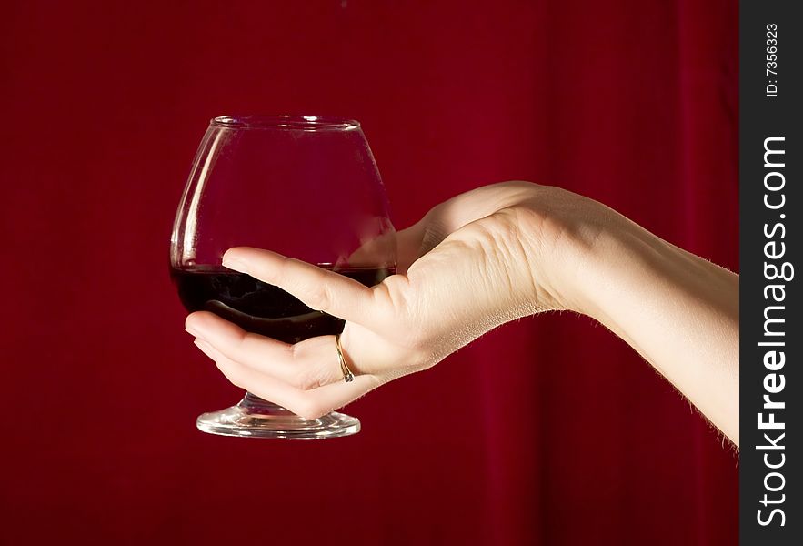 Woman's hand holding a glass of red wine