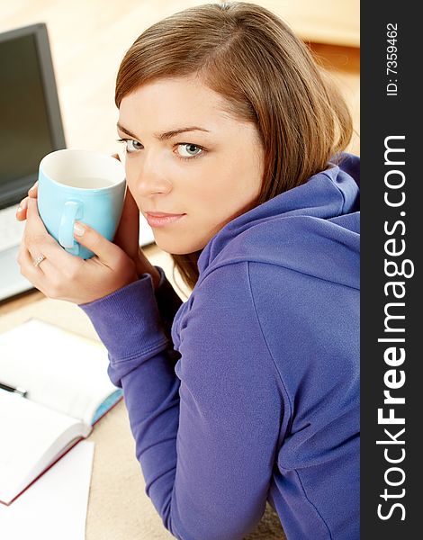 Beautiful woman resting in home with cup, laptop and papers. Beautiful woman resting in home with cup, laptop and papers