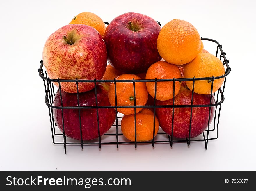 Apples and tangerines (mandarines) in a basket on a light background. Apples and tangerines (mandarines) in a basket on a light background