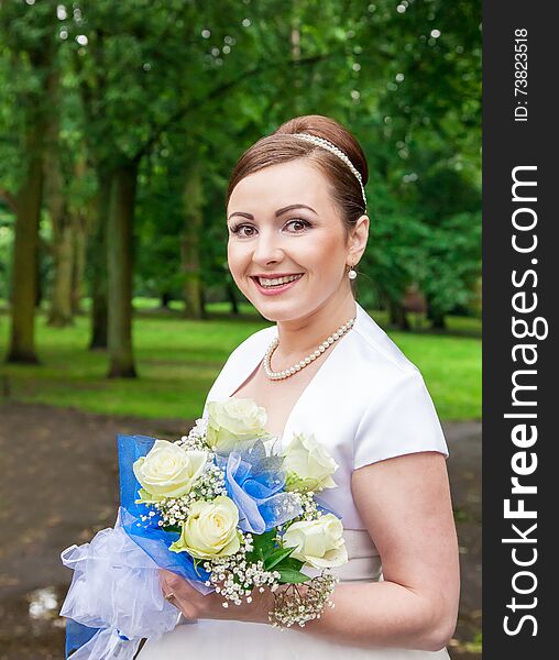 Young Smiling Bride With A Bouquet Of Roses