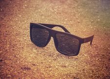 Black Sunglasses On The Beach In The Morning Royalty Free Stock Photography Black Sunglasses On The Beach In The Morning Royalty Free Stock Photography