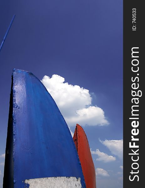 Blue and red abstract sign and sky with clouds in background. Blue and red abstract sign and sky with clouds in background