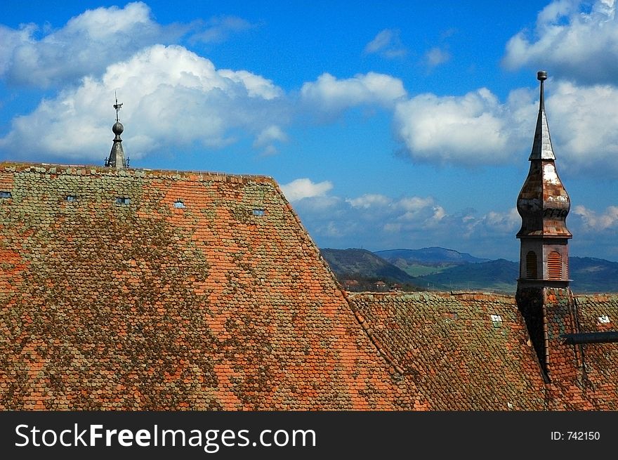 Roof of a gothic cathedral, against a blue cloudy sky. Roof of a gothic cathedral, against a blue cloudy sky.