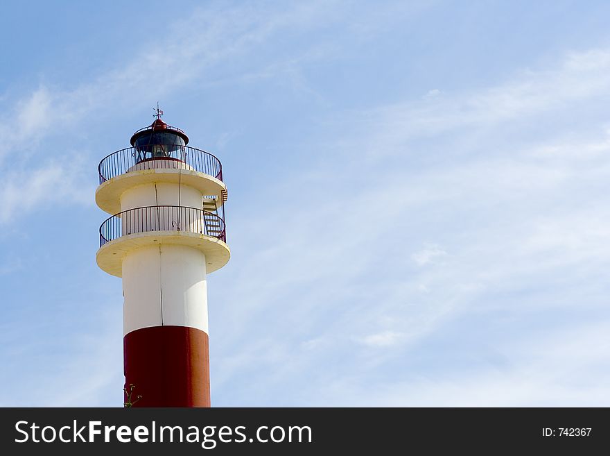Lighthouse over blue sky in a sunny day in a spanish coast town