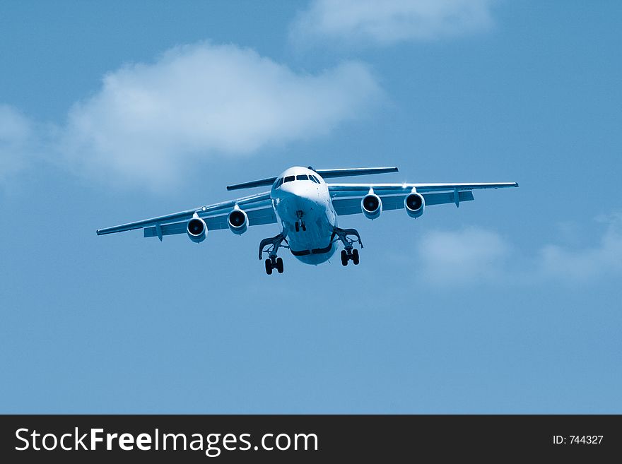 Small airliner coming into land. Blue toned image. Small airliner coming into land. Blue toned image