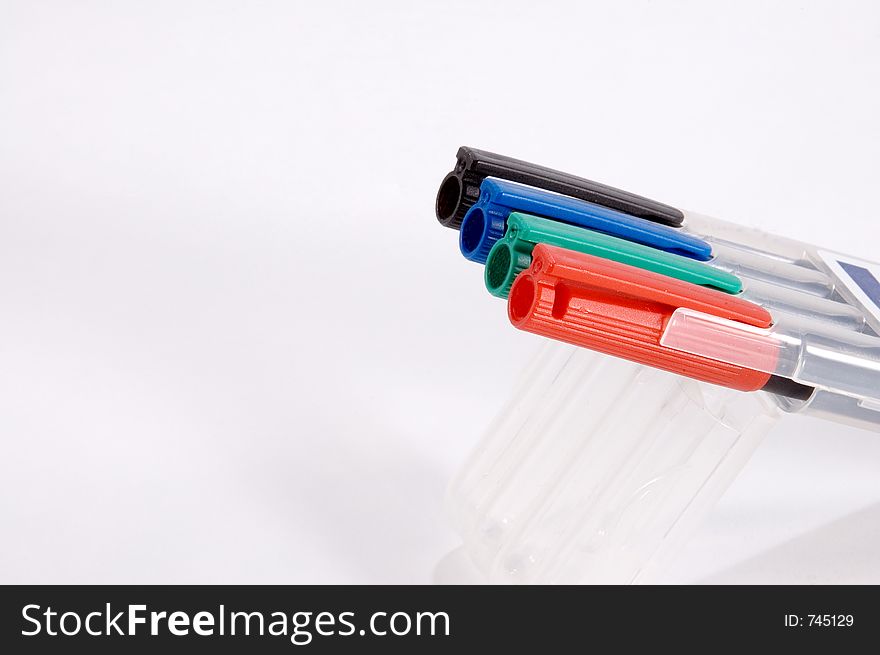 A set of four different colored markers in holder. A set of four different colored markers in holder