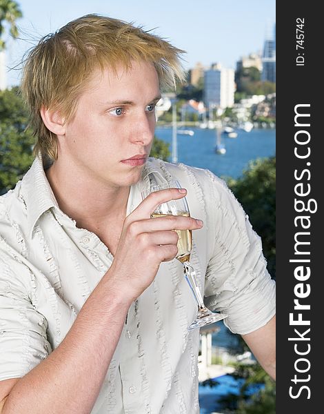 Young man drinking champagne on the balcony