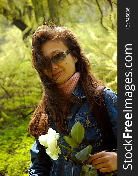 Young beautiful happy woman hiking in forest with a white rose. Young beautiful happy woman hiking in forest with a white rose