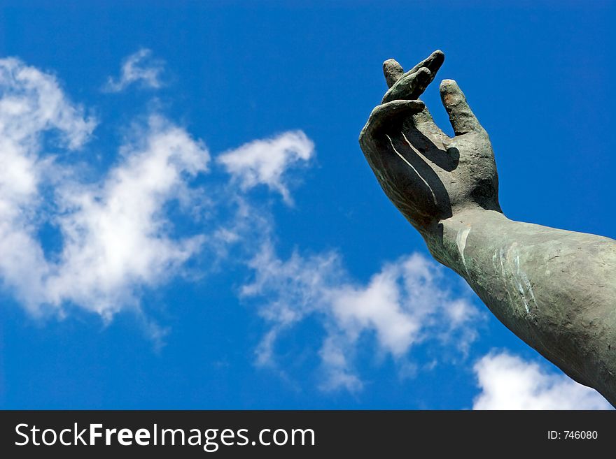 Stone hand on a background of the blue sky. Stone hand on a background of the blue sky