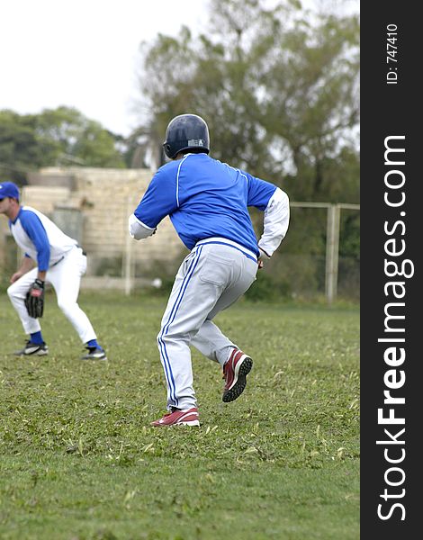 Action during a baseball game. Batter runs for base. Action during a baseball game. Batter runs for base.